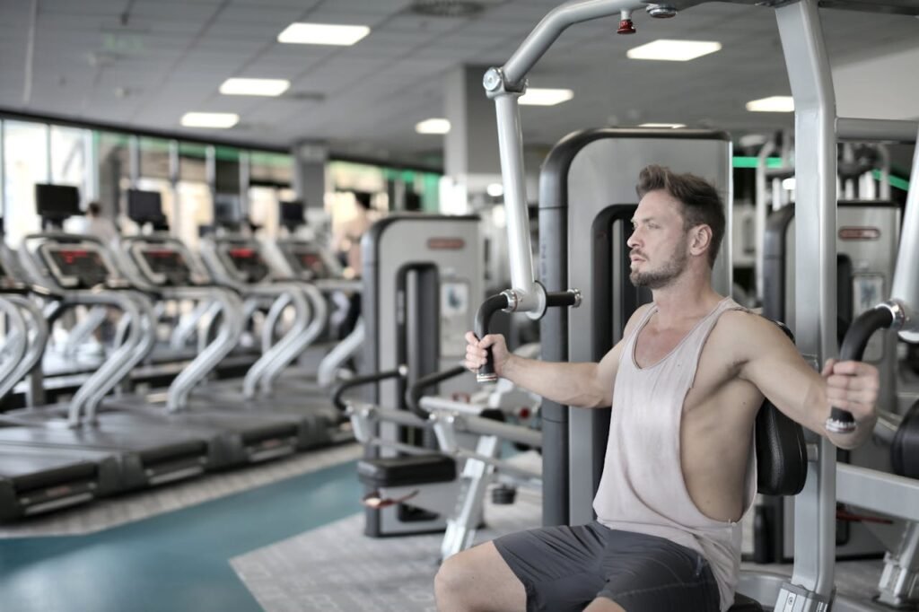 Man exercising on chest press machine in a modern gym, showcasing fitness and strength.. Gimnasio en Casa