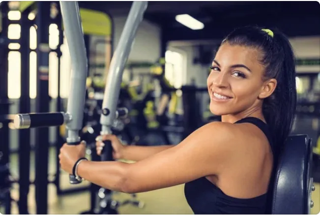 Atleta finalizando entrenamiento en máquina de pecho Pec Deck con resultados visibles en pectorales