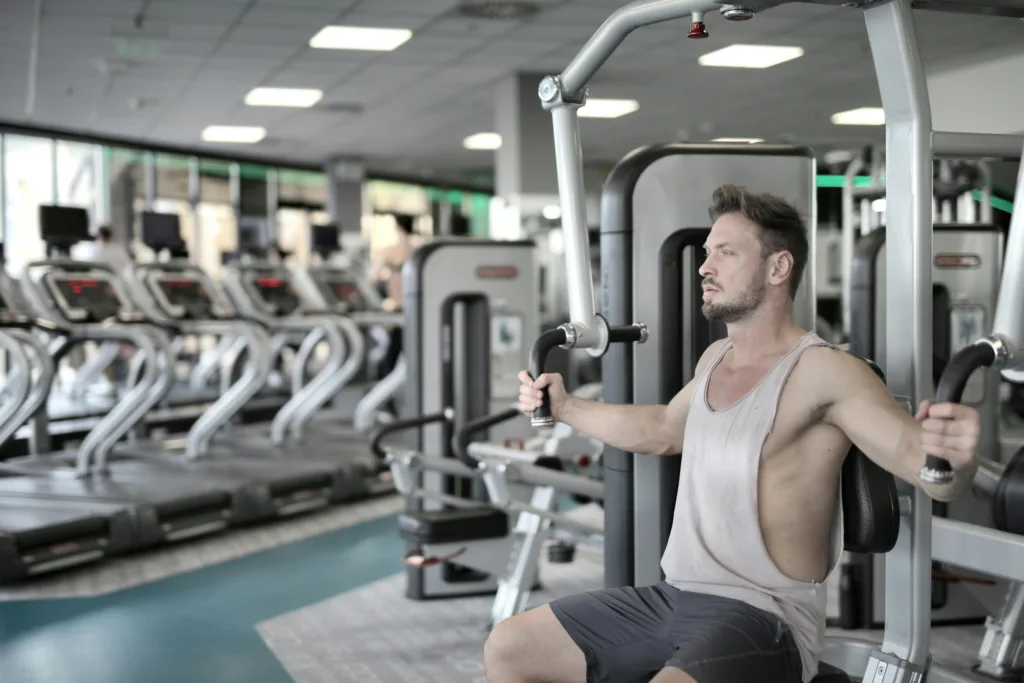 Atleta en máquina de pecho Pec Deck con asiento ajustado y técnica correcta para pectorales